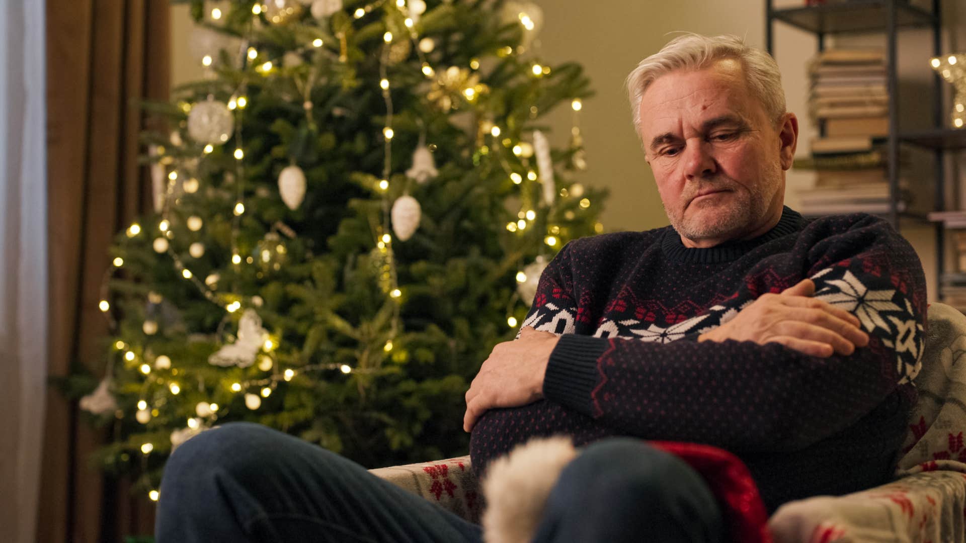 serious older man sitting in chair at home