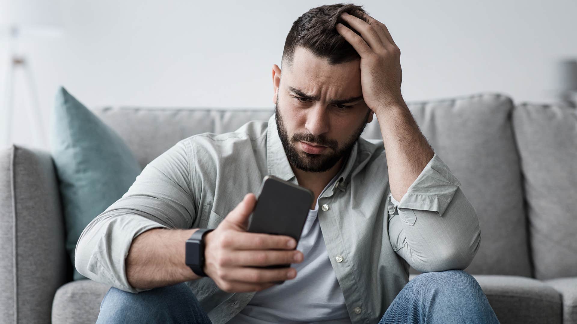 man who hates his life and dislikes change looking at his phone