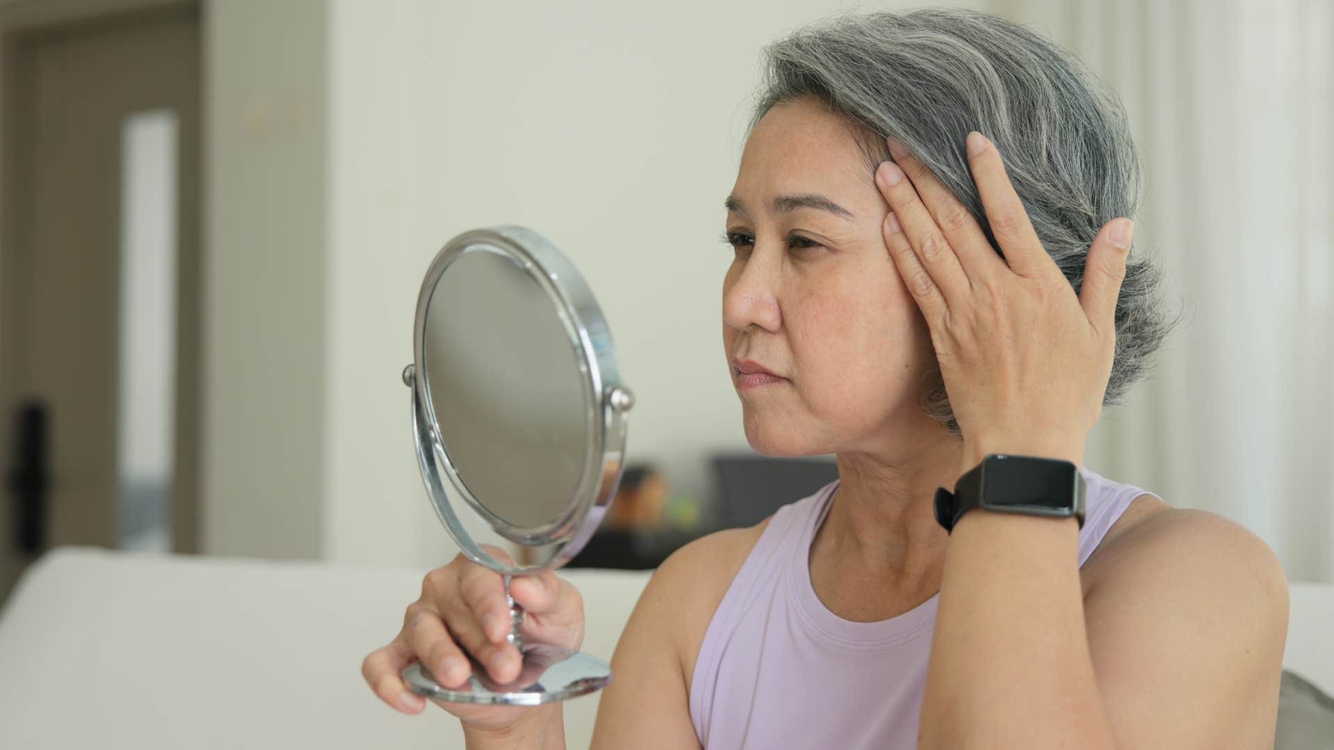 insecure woman looking at herself in a mirror