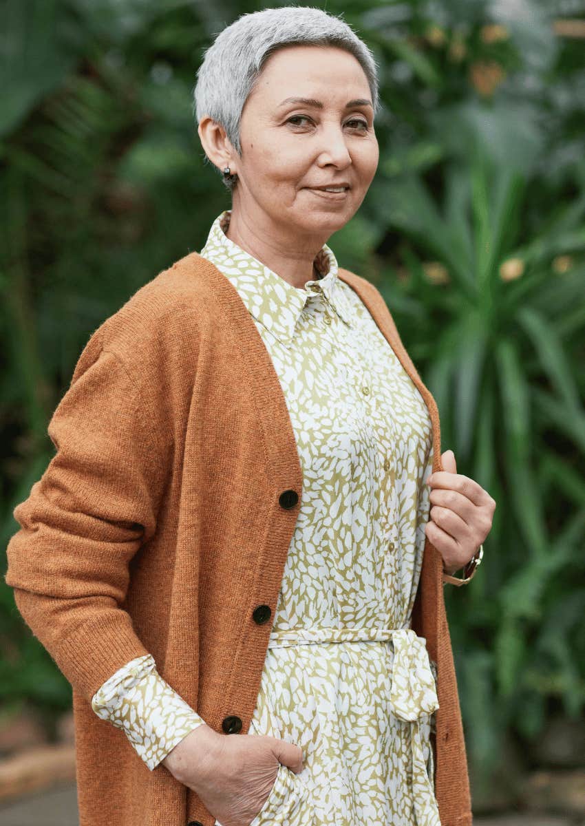 older woman wearing cardigan smiling softly