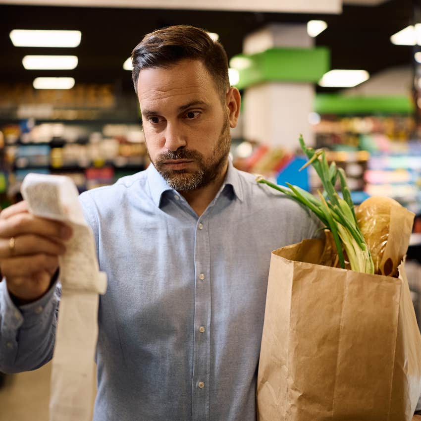 Dad looking at grocery bill deciding if he can afford school supplies