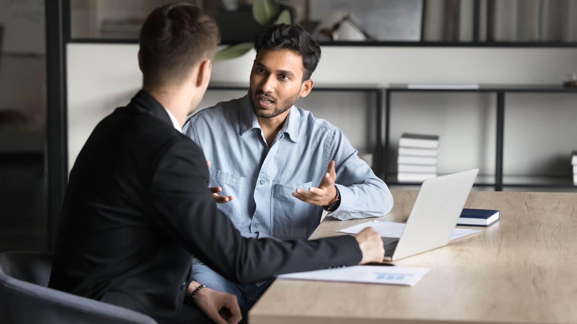 man in blue telling coworker let me finish my thought and then i'll be happy to hear yours