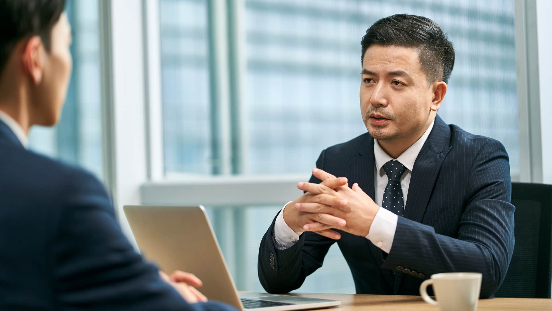 man in suit telling coworker that's an interesting perspective what led you to that conclusion