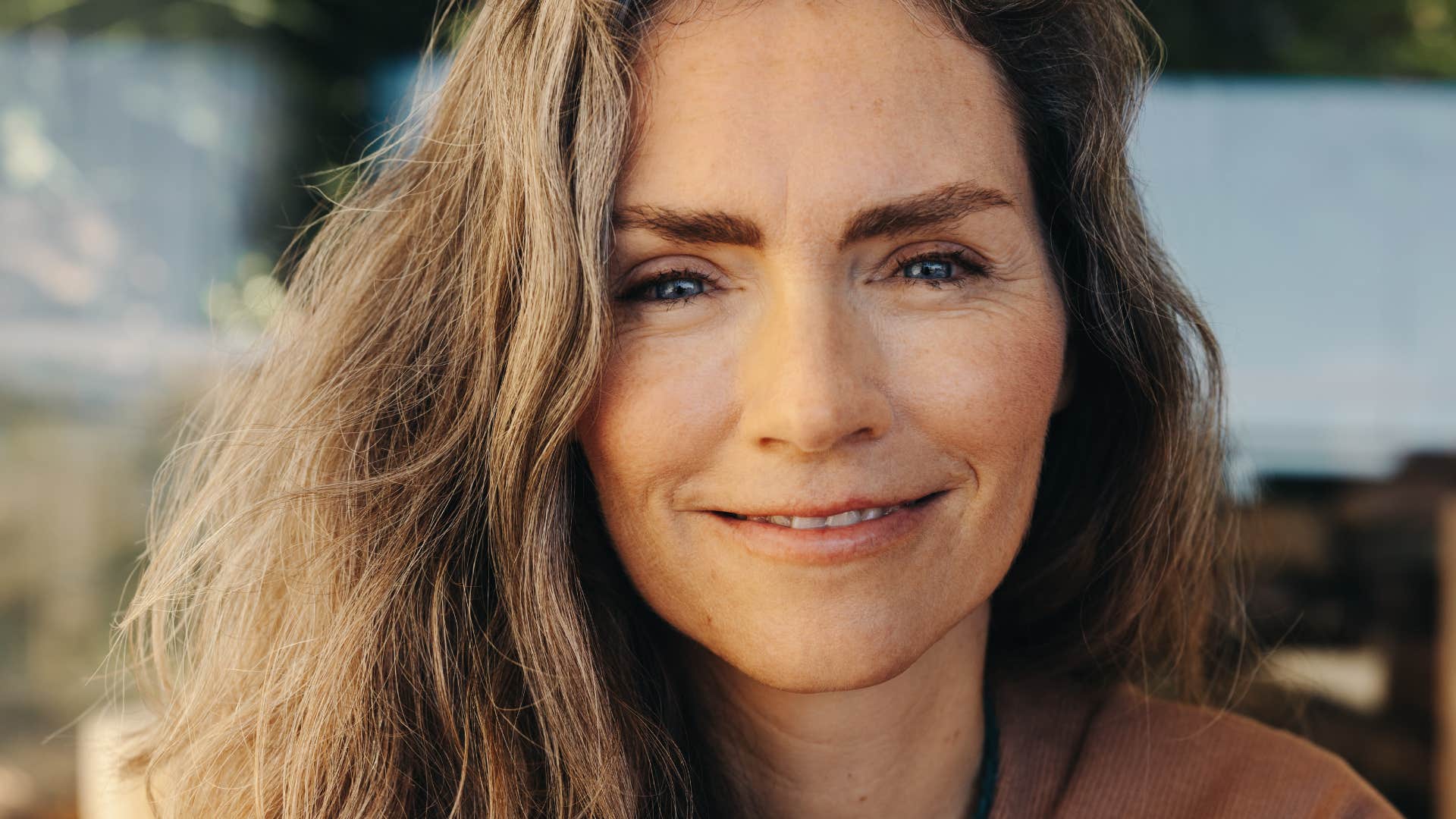 intuitive woman smiling in the sunshine