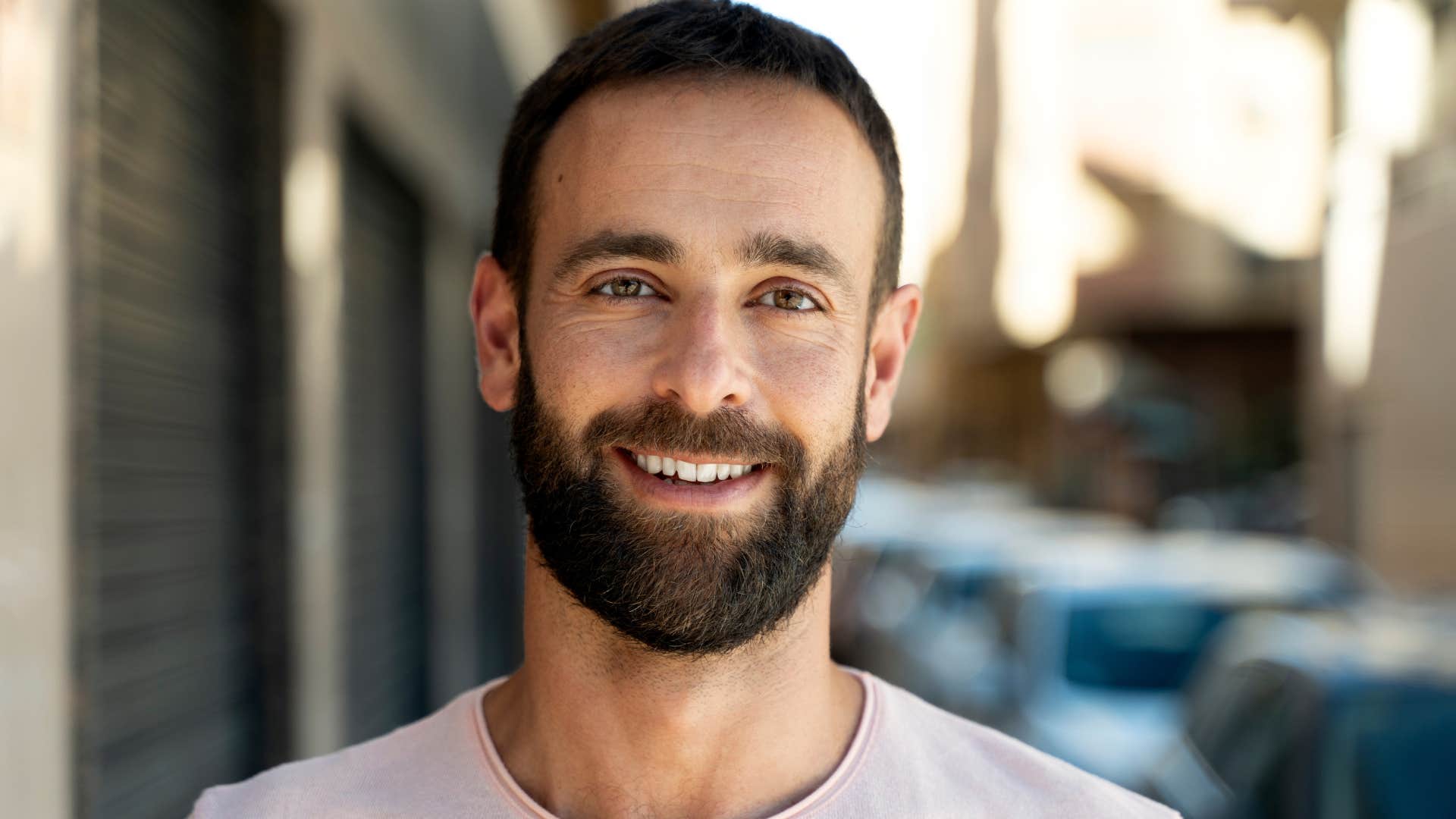 confident man smiling standing outside