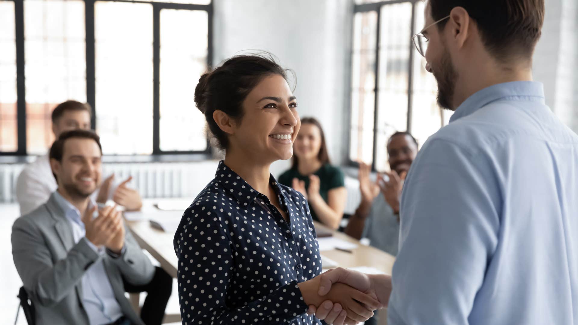 reliable woman shaking hands with boss smiling