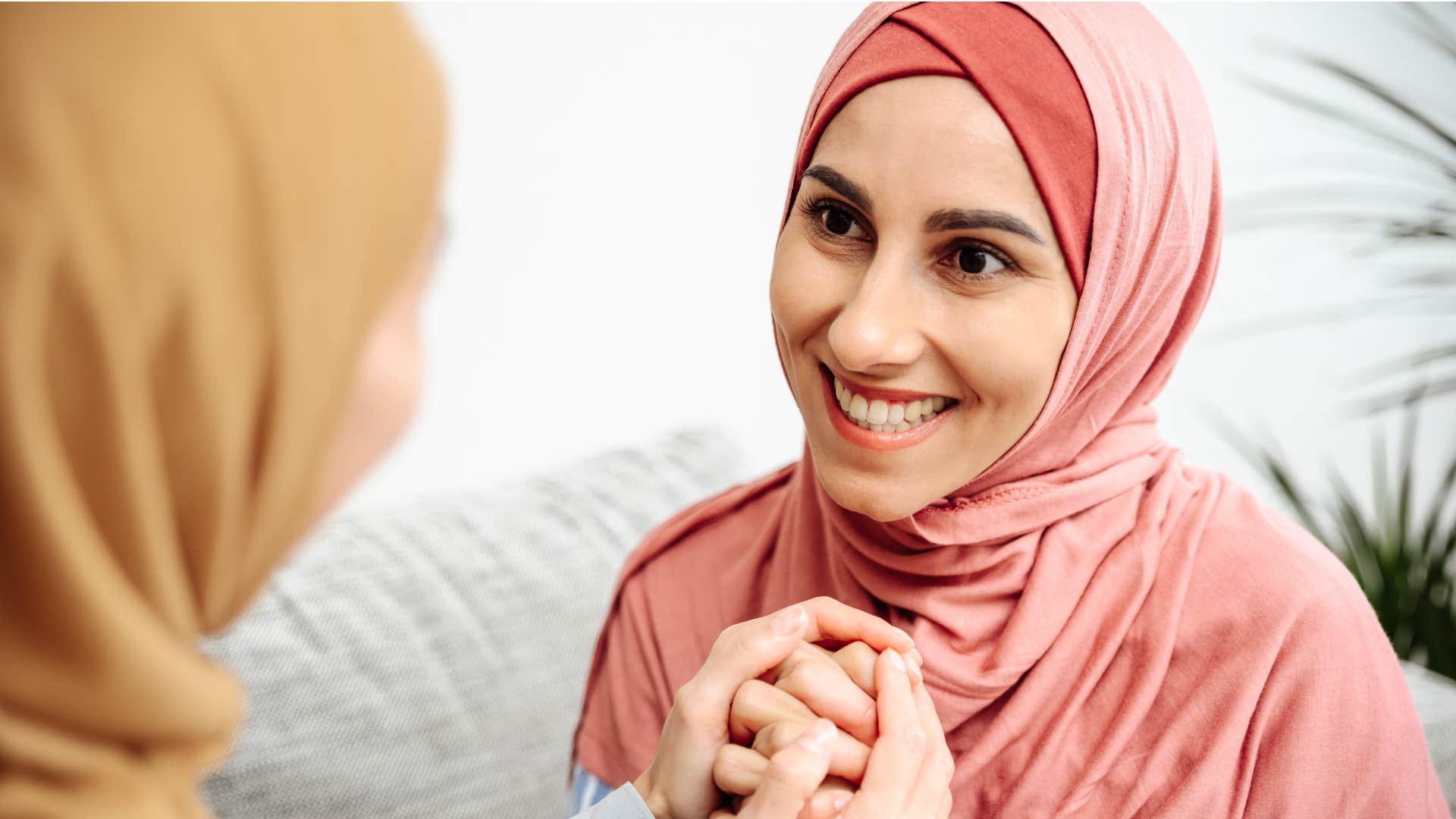 respectful woman holding friend's hand smiling