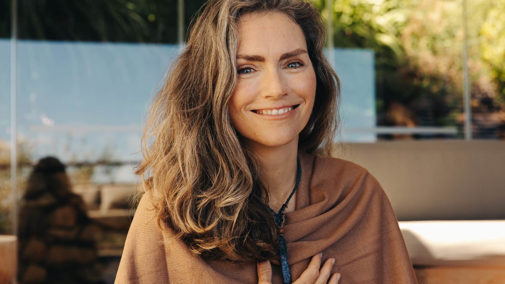 spiritual woman smiling holding her chest