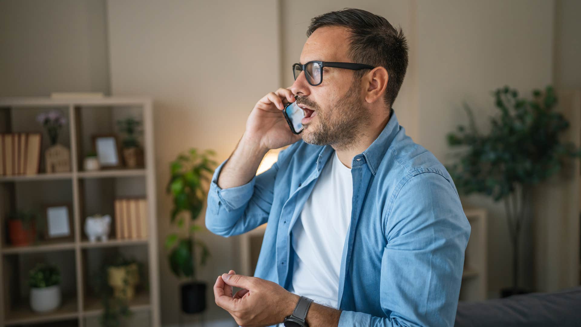 man in white shirt on phone as he says he's been really busy lately