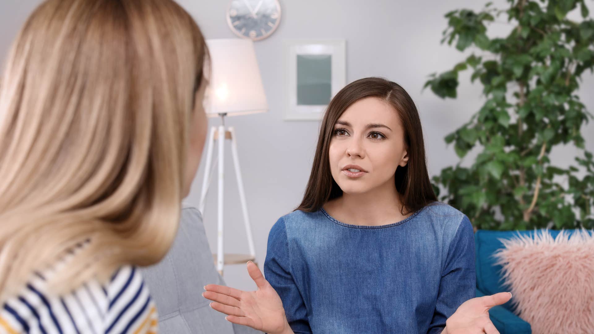 woman in denim dress telling other woman i was planning on reaching out soon