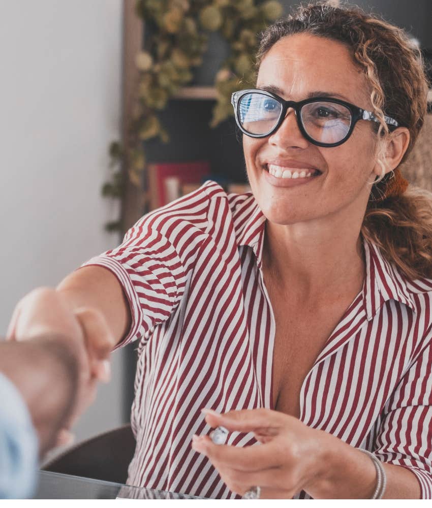 woman shaking hands being judged on trustworthiness and respect