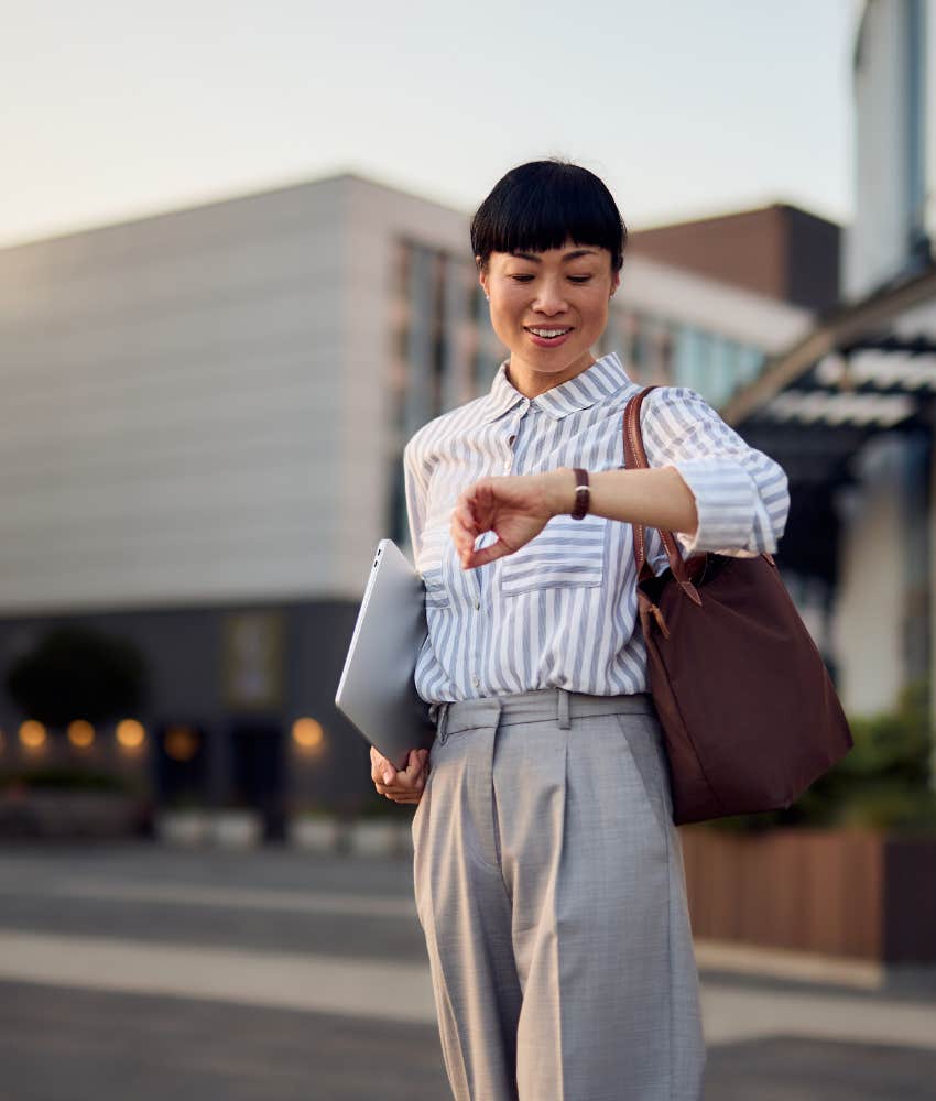 Woman who lays her clothes out for the next day looking at watch great at time management