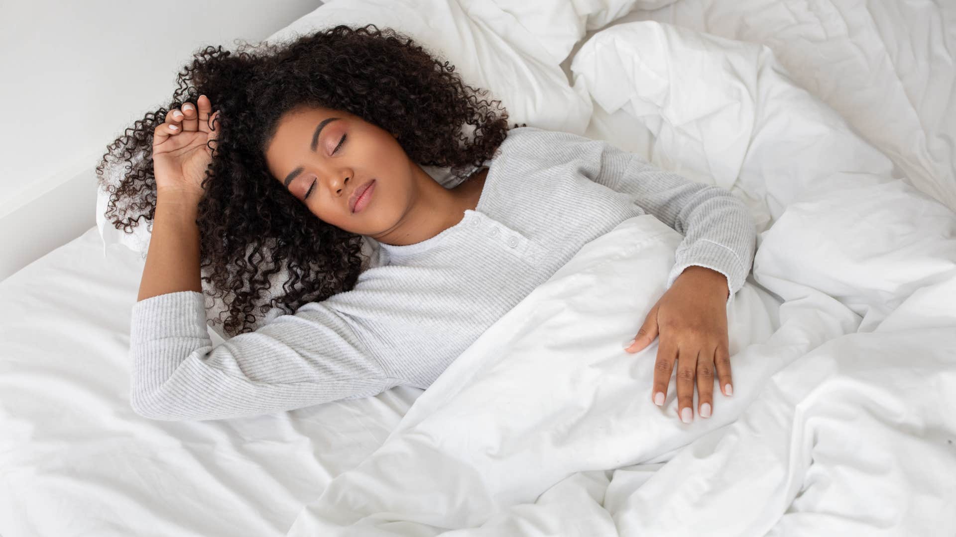 woman is a comfort seeker as she sleeps peacefully in white bed