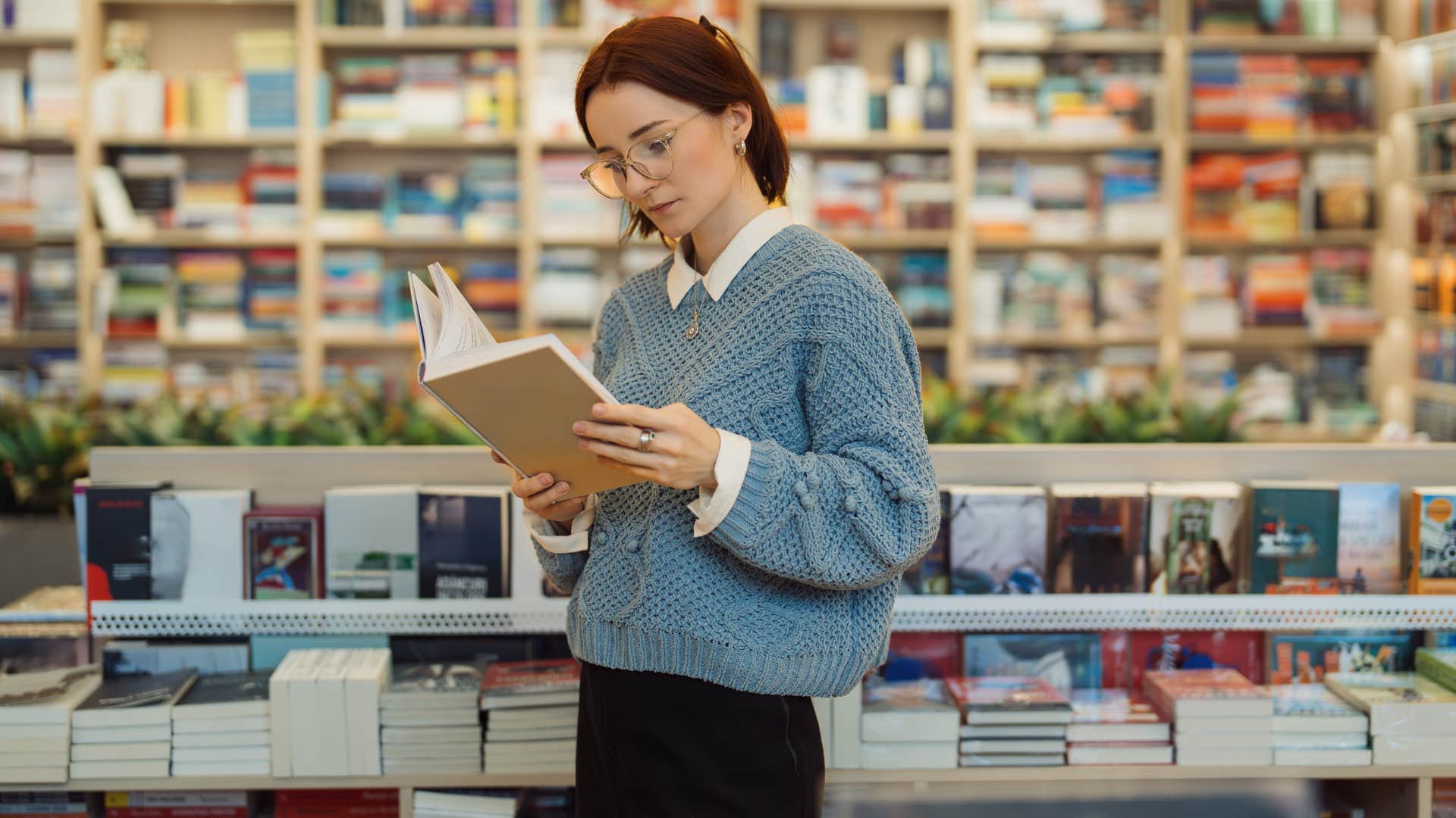 woman in blue reading book as she's detail aware