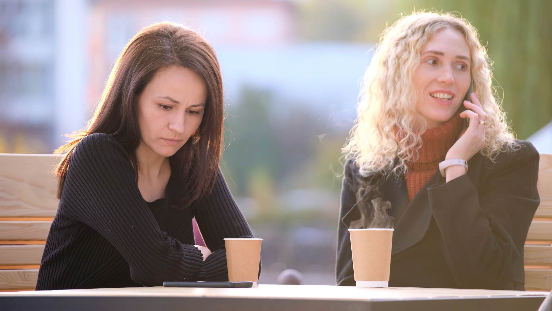 woman on a phone call ignoring friend going through a hard time