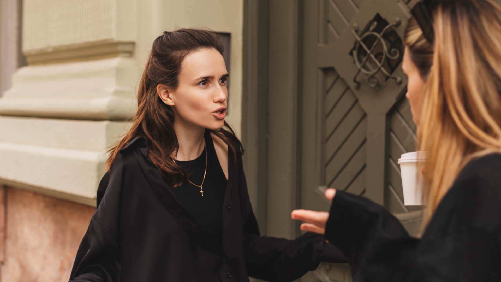 woman holding silent grudge while yelling at friend