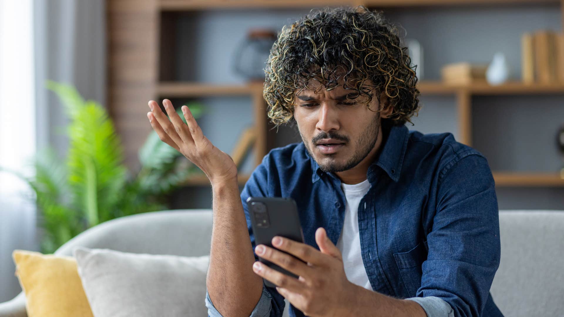 confused man looking at phone after friend stopped reaching out