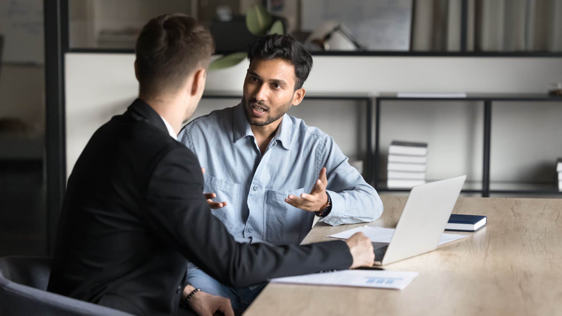 man in blue shirt asking coworker how will that work in the long run