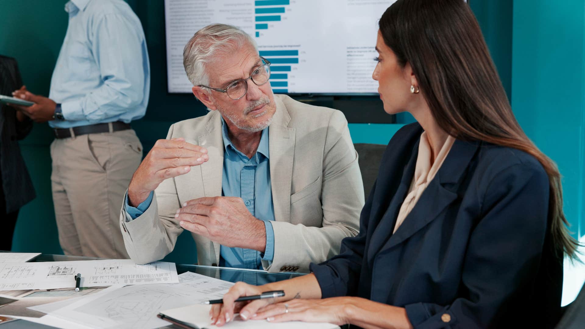 man in white jacket asking coworker What did you learn