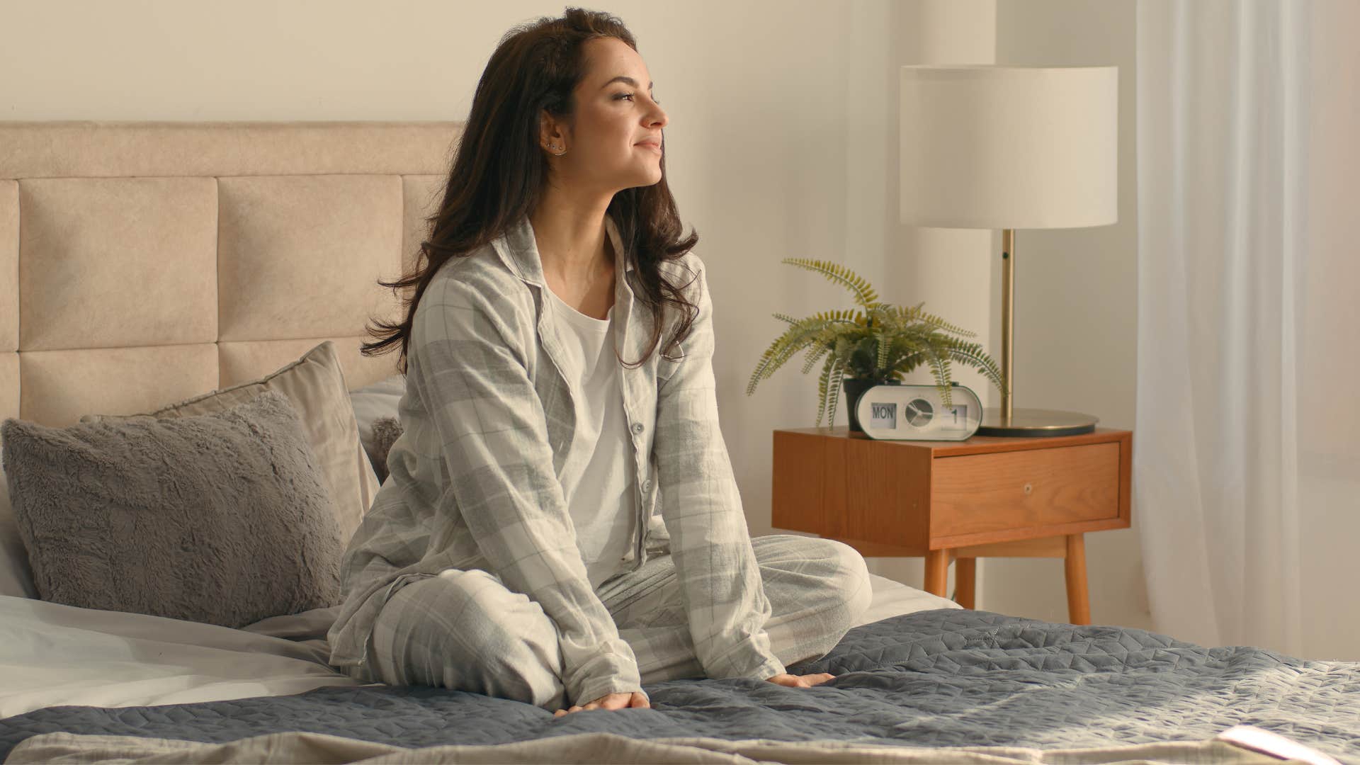 woman in pajamas looking out window as she's comfort driven