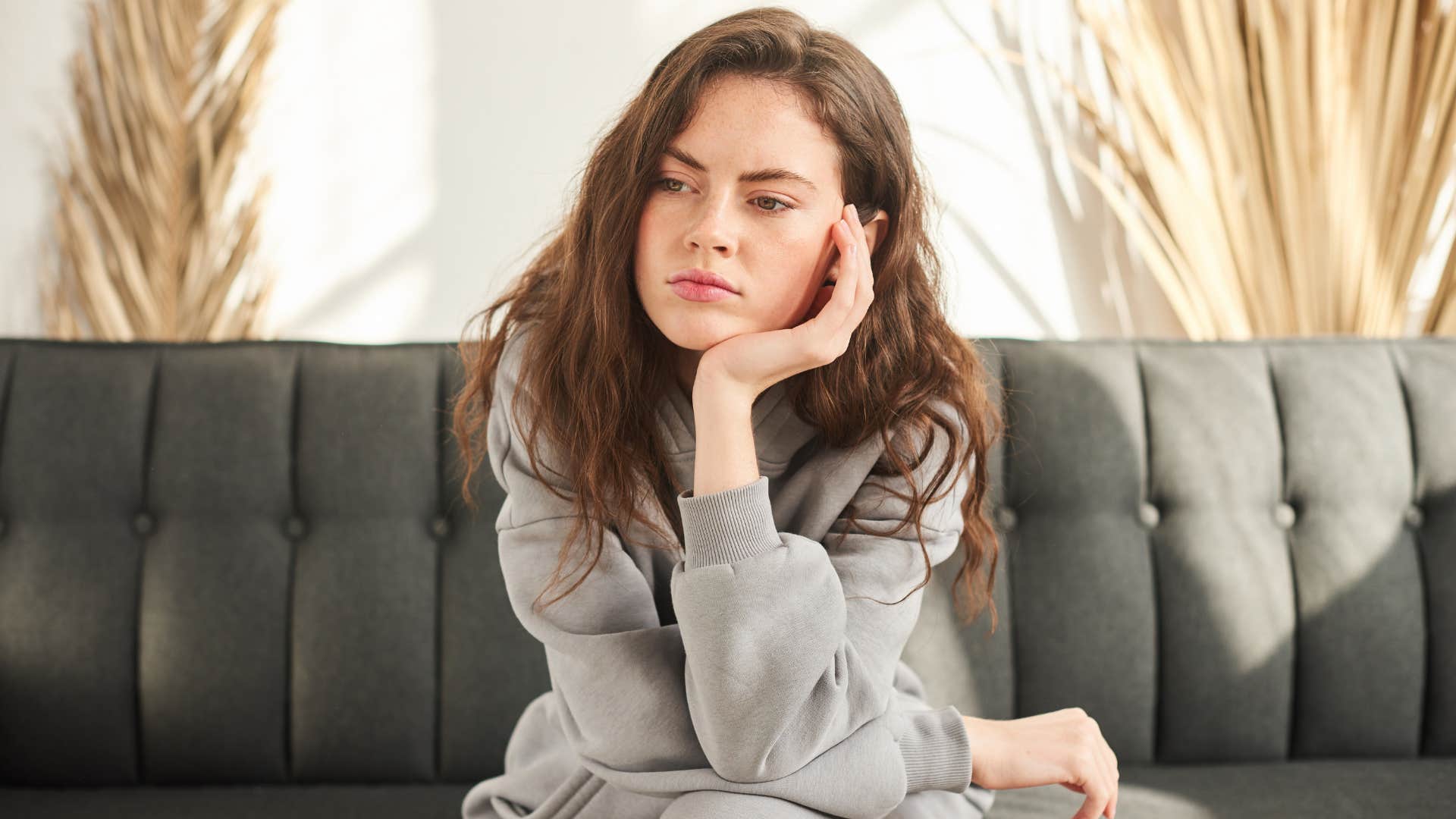 woman on couch as she thinks deeply