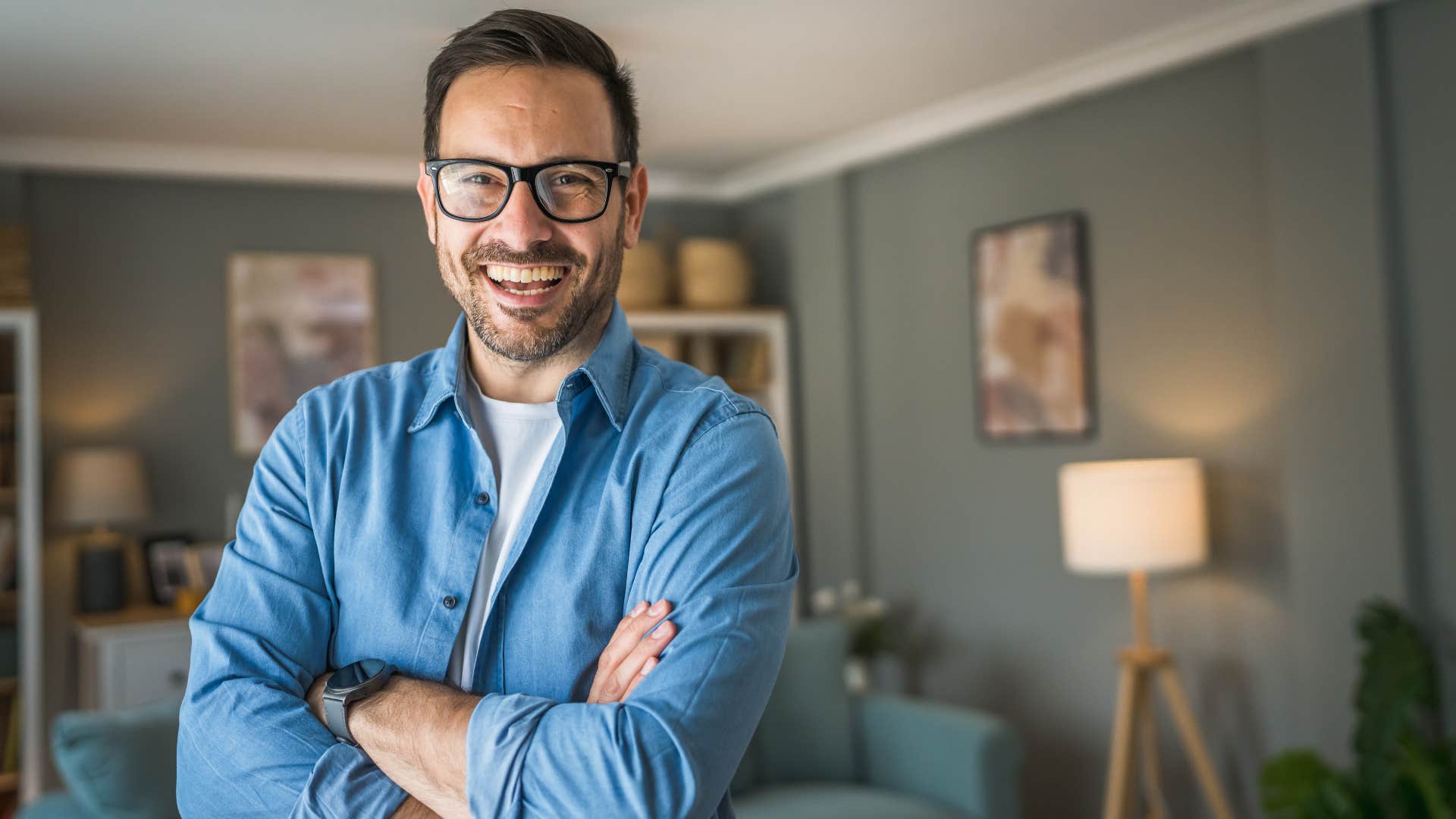 genuine man in blue crossing arms happily