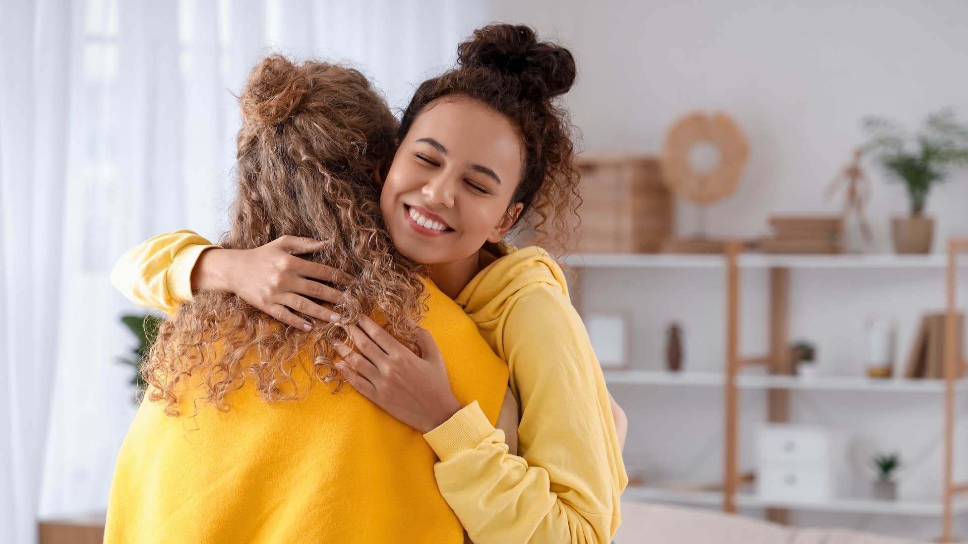 two women in yellow hugging as they have high emotional intelligence