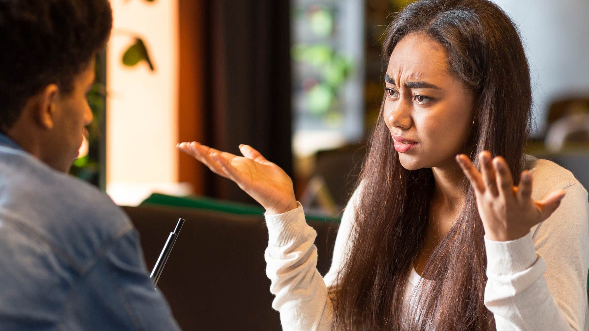 annoying woman shrugging and saying everyone else does it to her partner