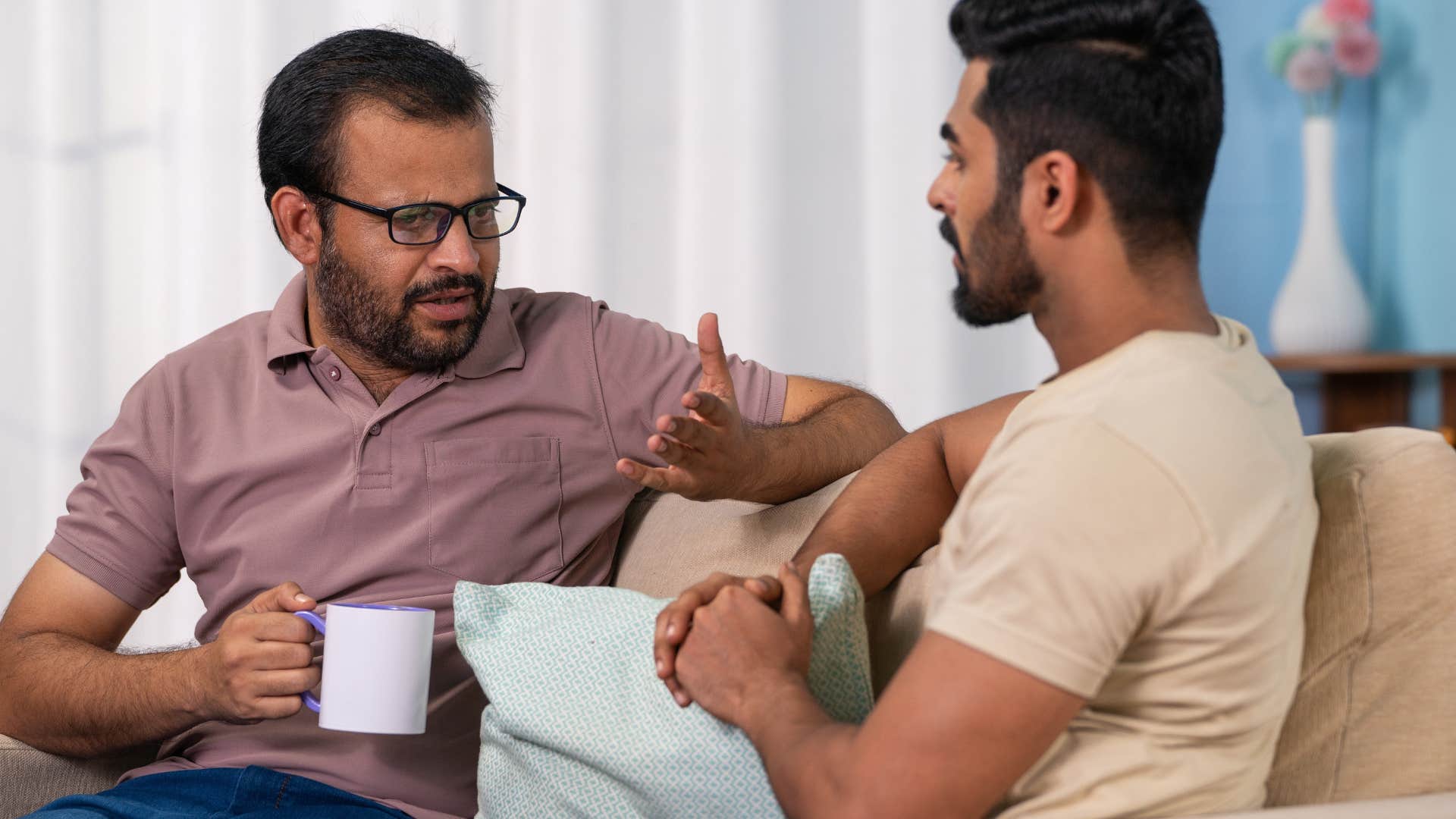 annoying man telling friend to just relax in conversation