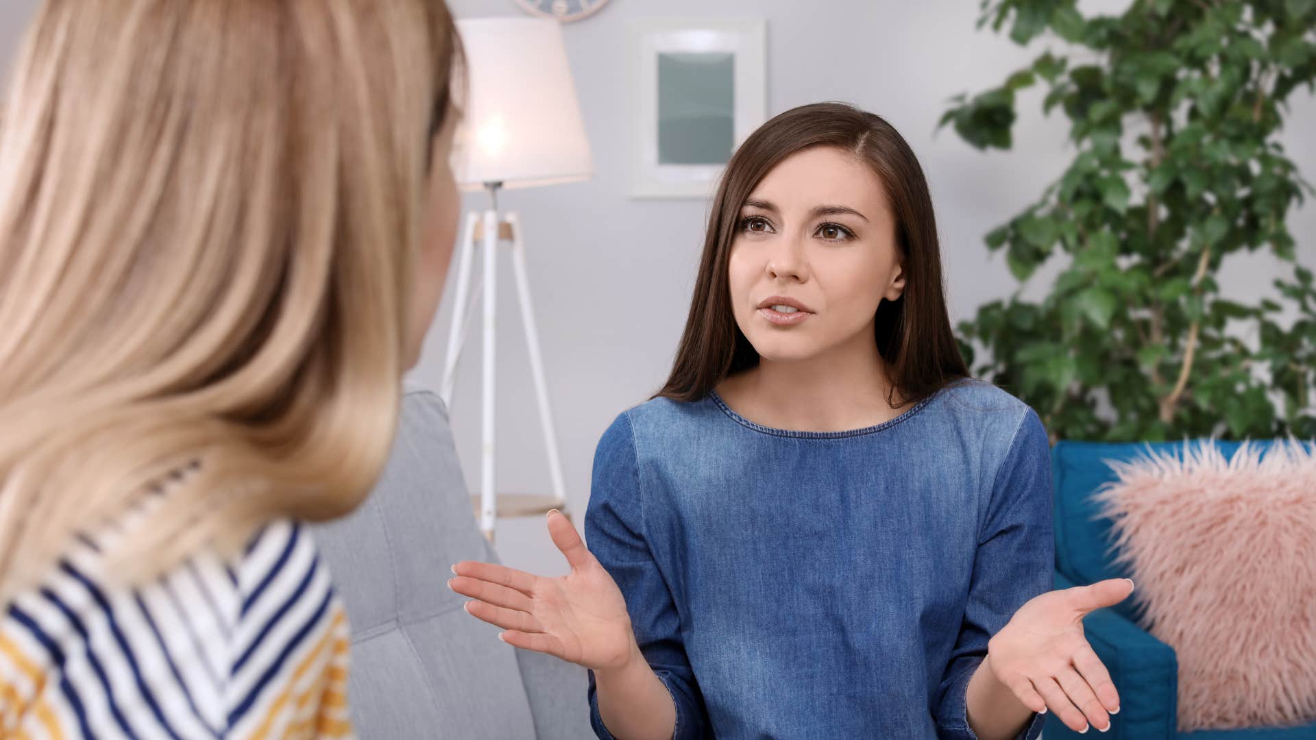woman arguing with friend sitting on couch