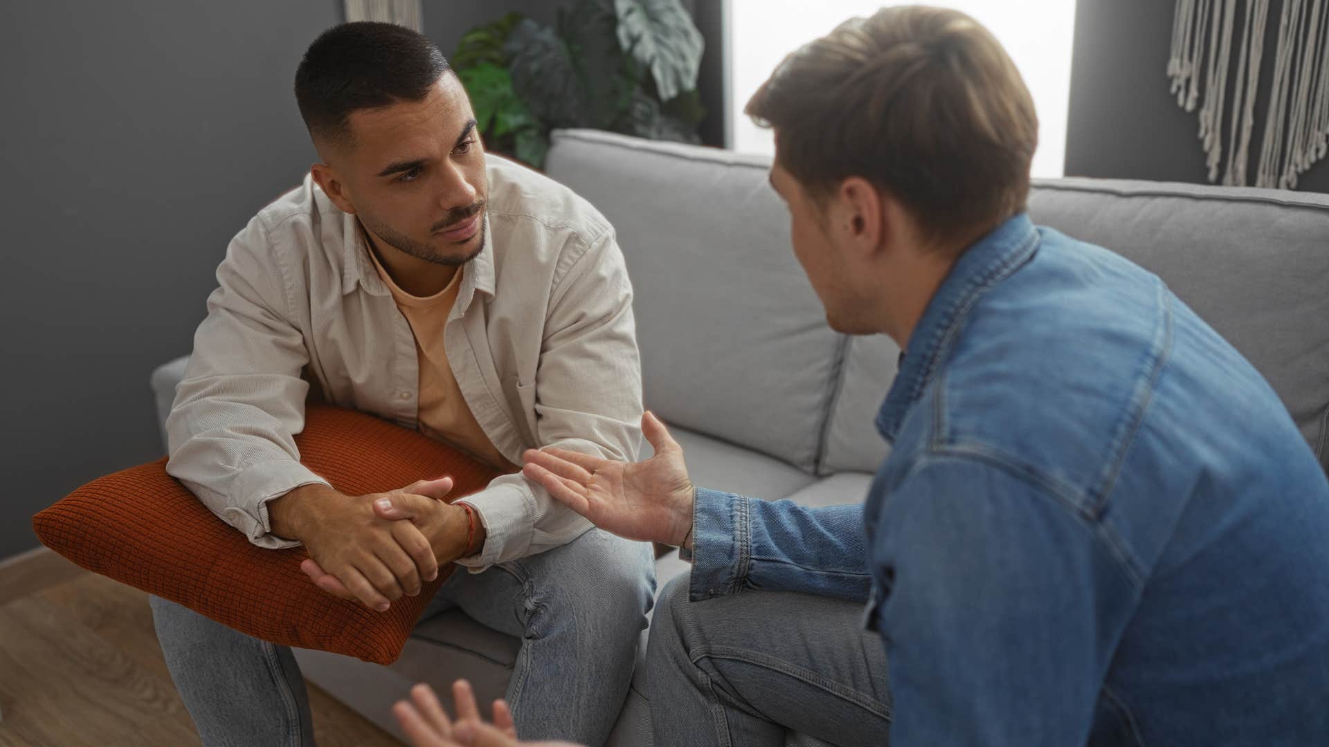 two men having serious conversation on couch