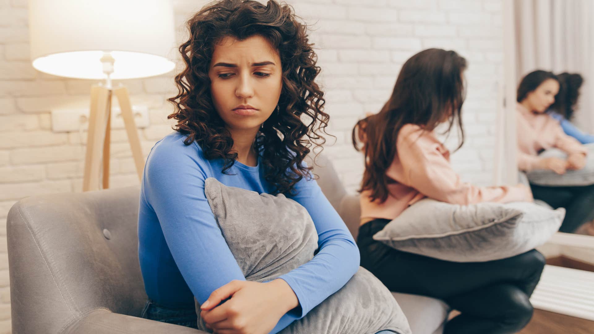 Bitter woman saying "I'm fine" to her friend.
