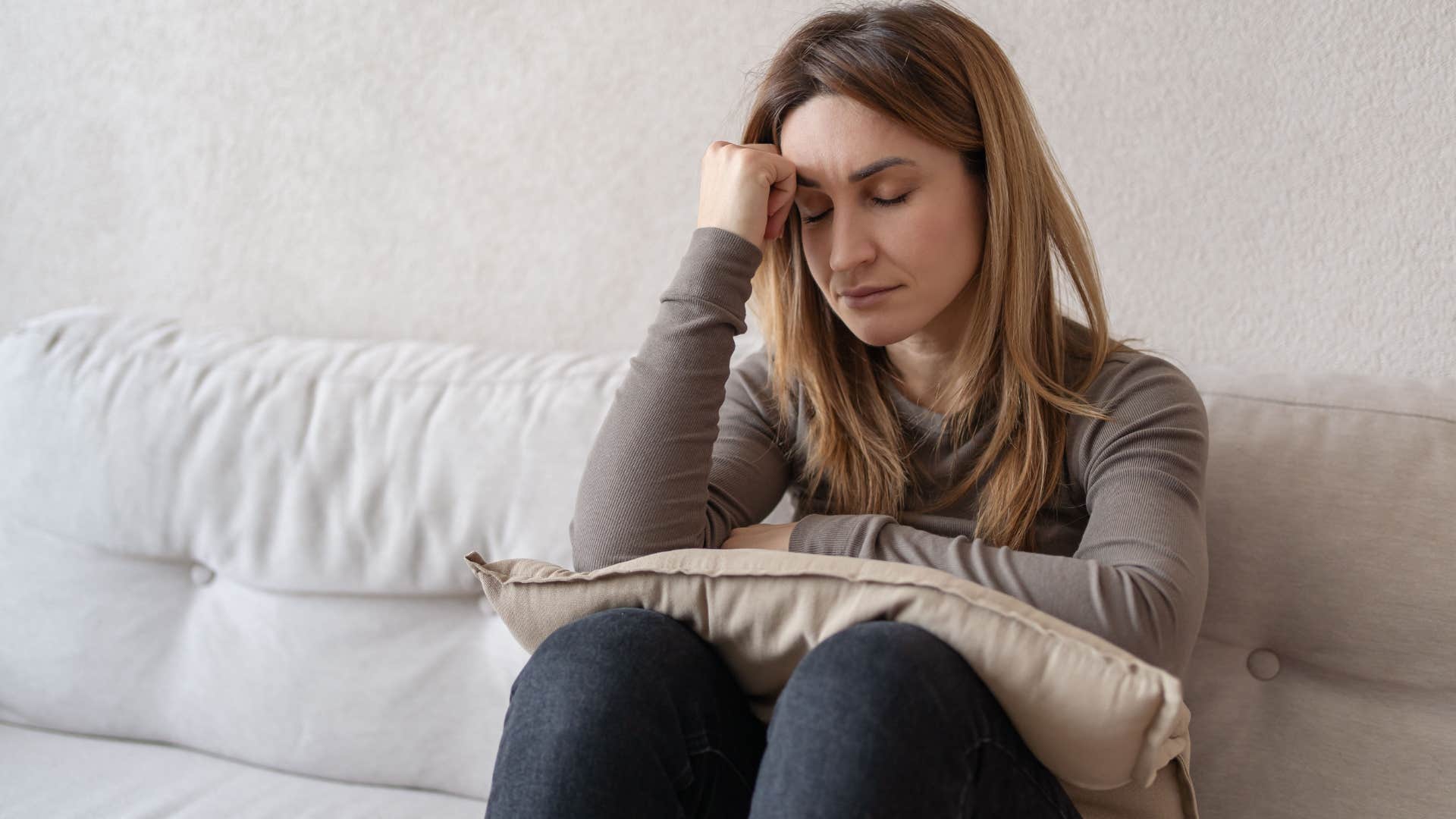 Upset woman thinking "I just have horrible luck" at home.