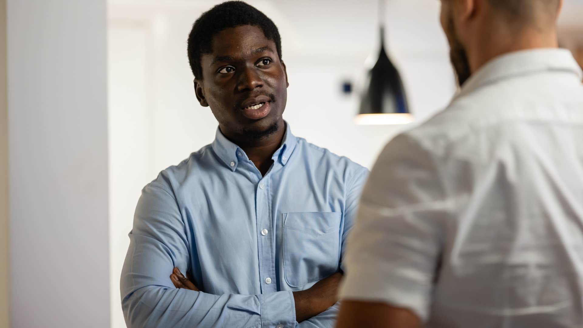 Man saying "no offense, but..." to a friend.