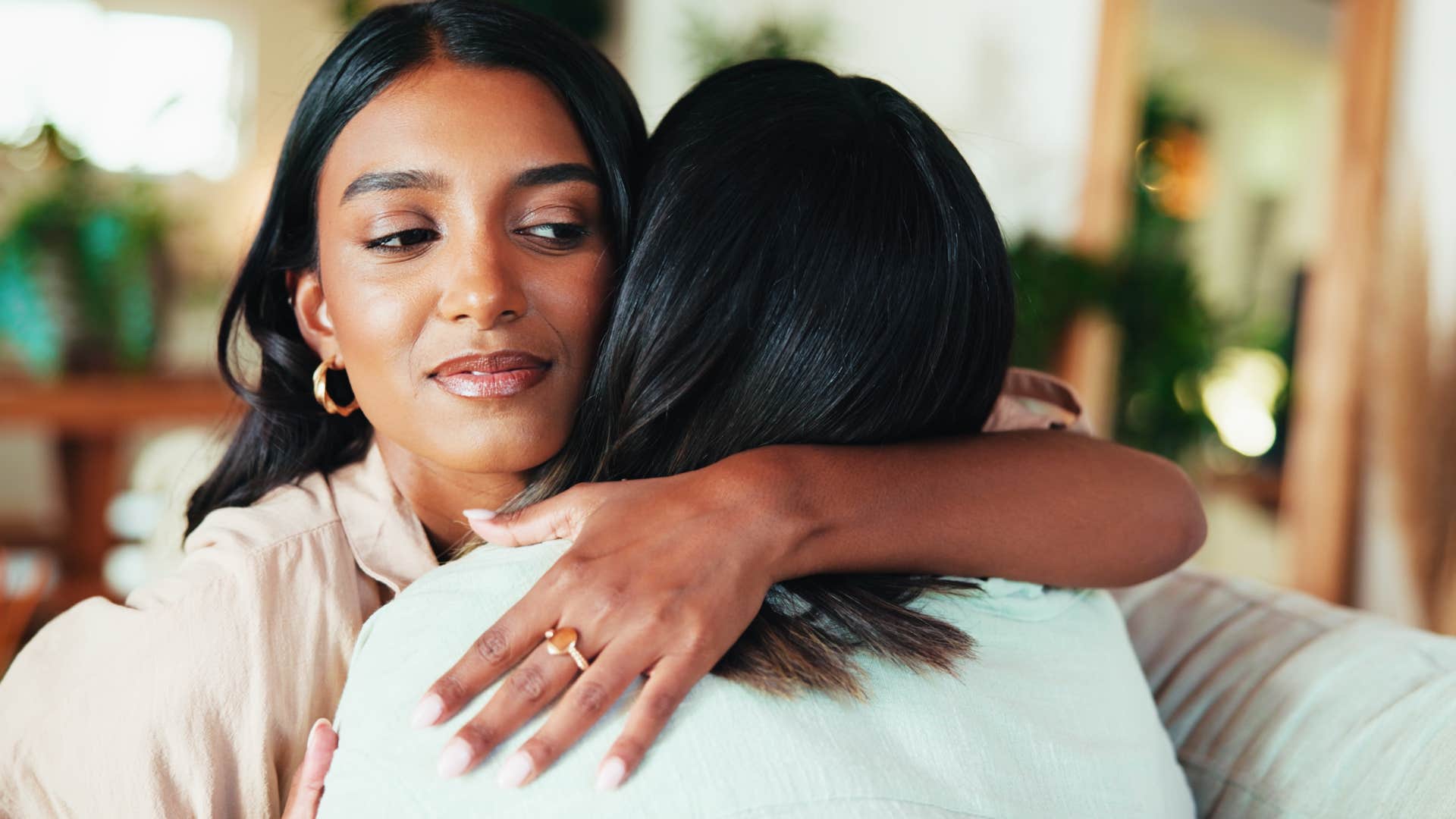 woman hugging friend annoyed by being around fake positivity