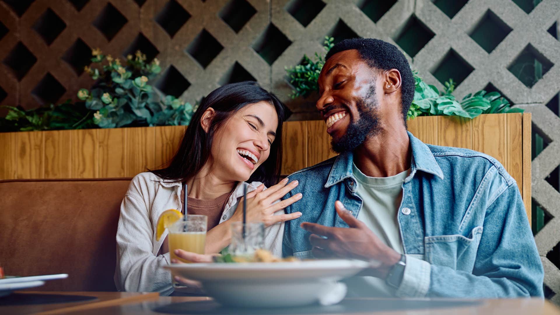 Laughing couple share meal showing extroverts entertain