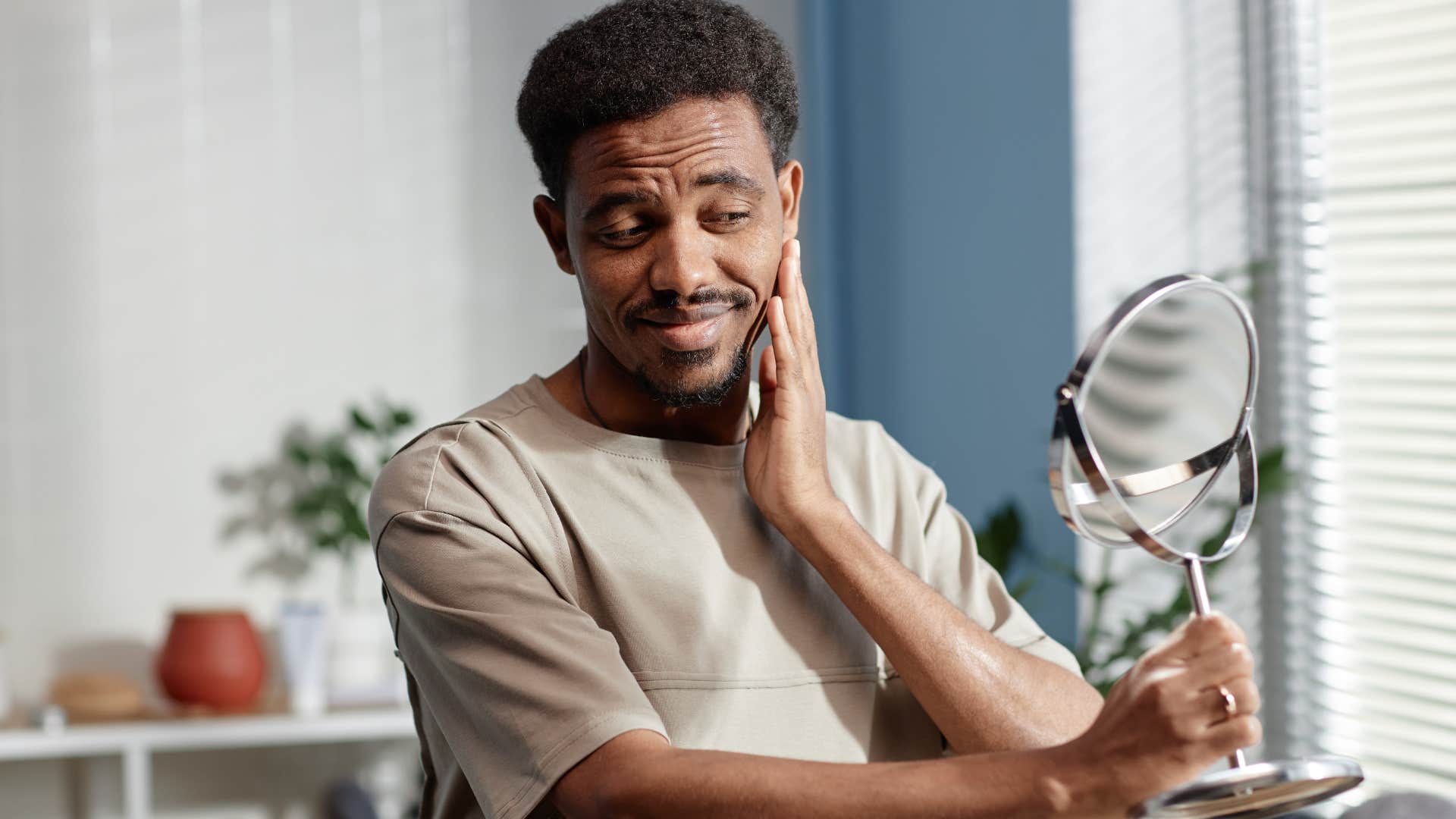 optimistic man looking at himself in a mirror
