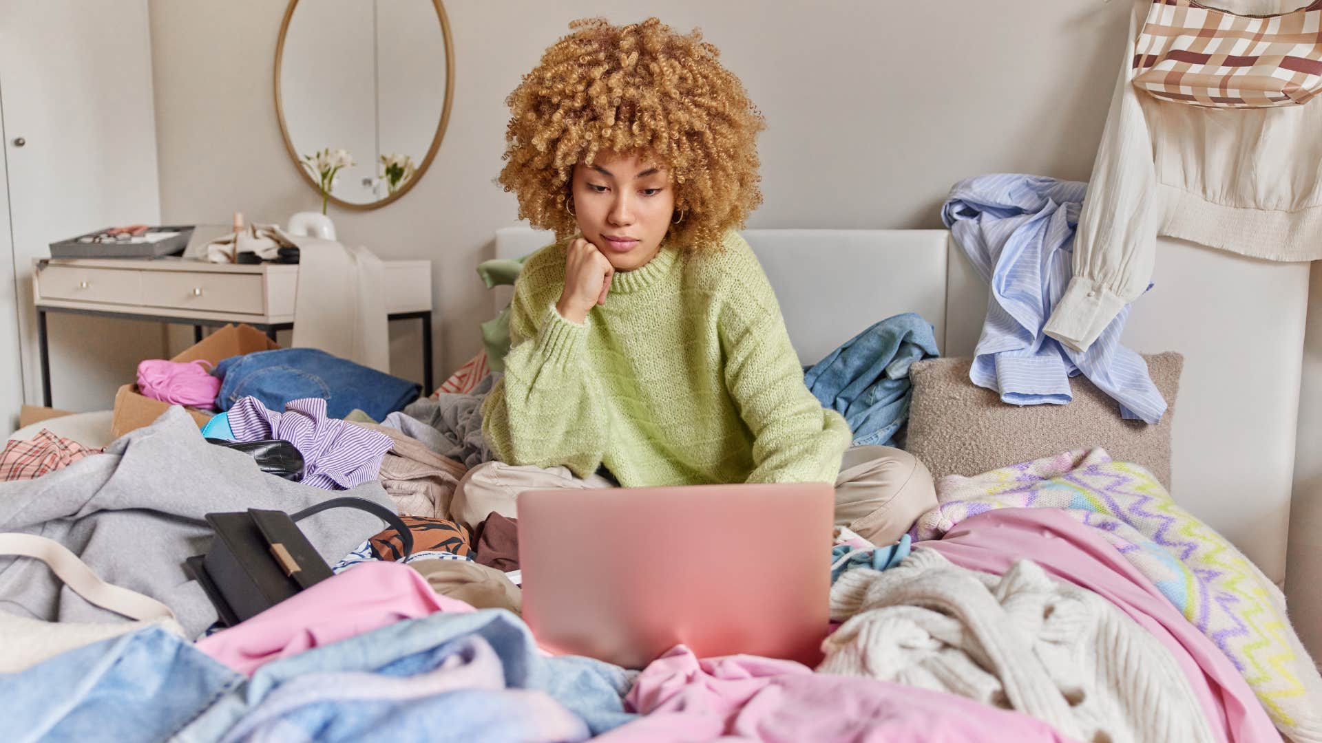 woman sitting on messy bed