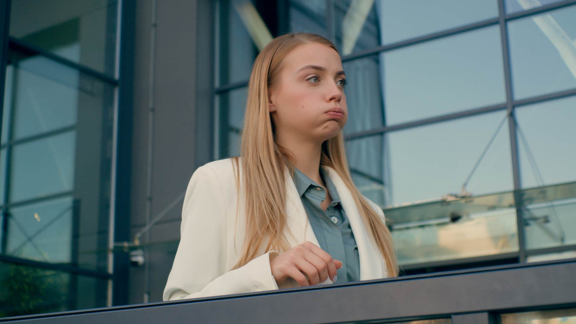 woman sighing heavily standing outside of work building