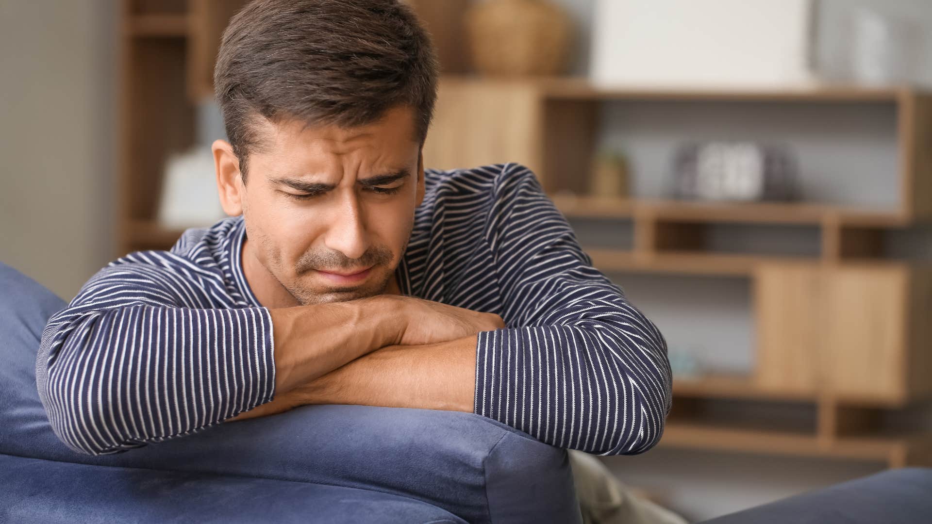 uneasy man sitting on couch