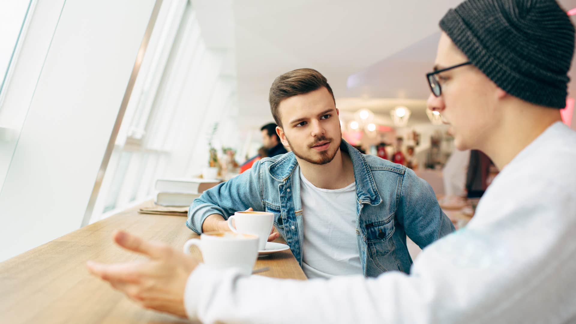 Upset man saying "let's just move on" with a friend.