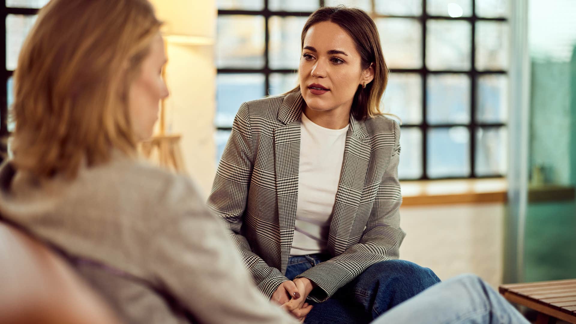 Woman saying "I never said that" to an upset friend.