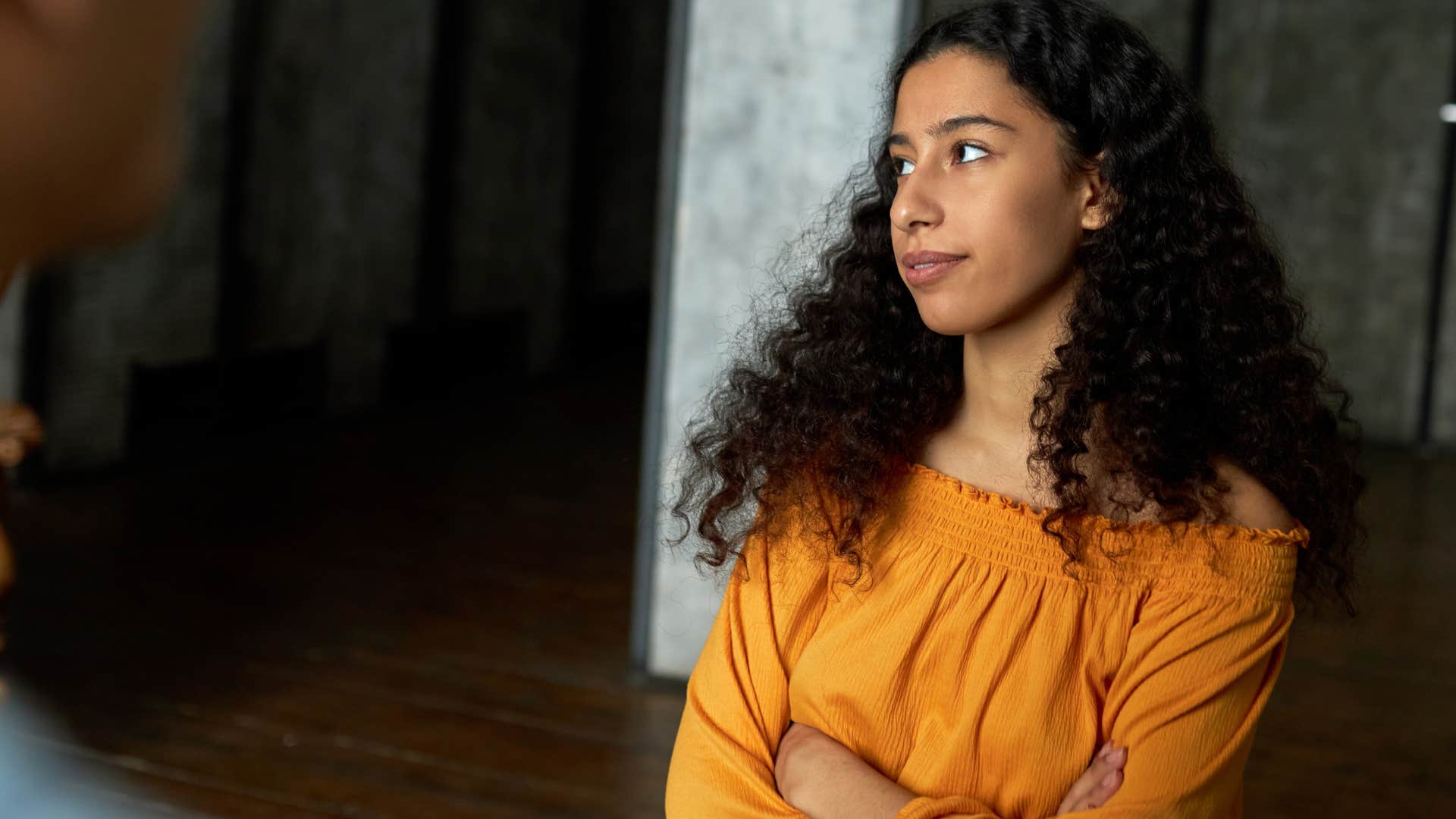 annoyed woman with her arms crossed telling friend I don't owe anything to you