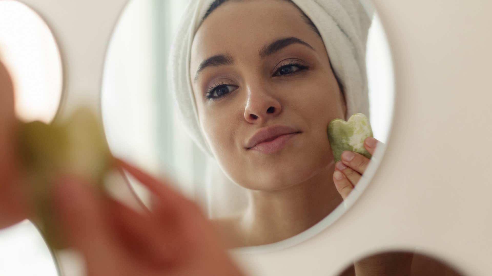 relaxed woman pampers herself with facial showing how to let go after break up