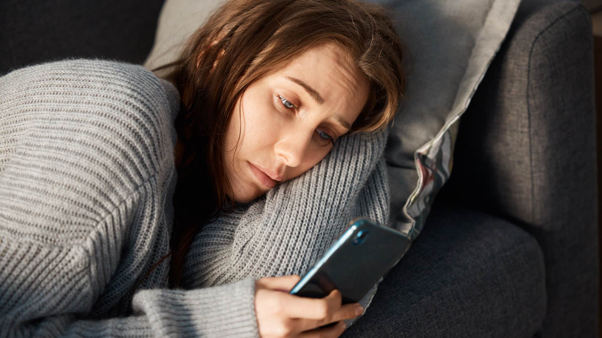 Woman who regularly cancels plans looking at her phone.