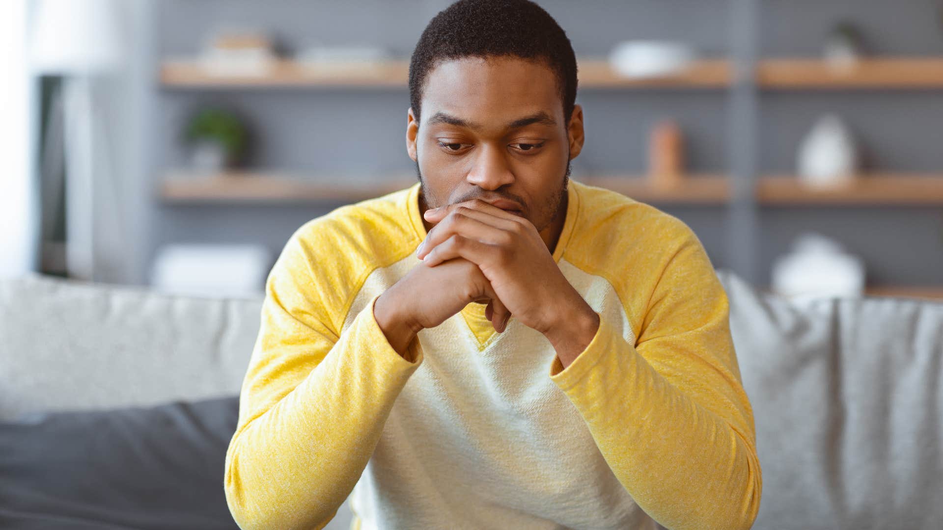 Man who's stopped reaching out first sitting alone at home.