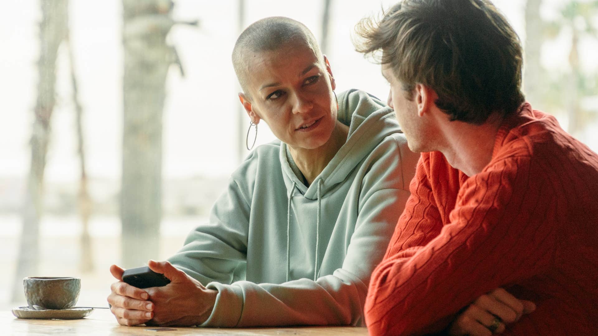 two friends having serious conversation sitting at table