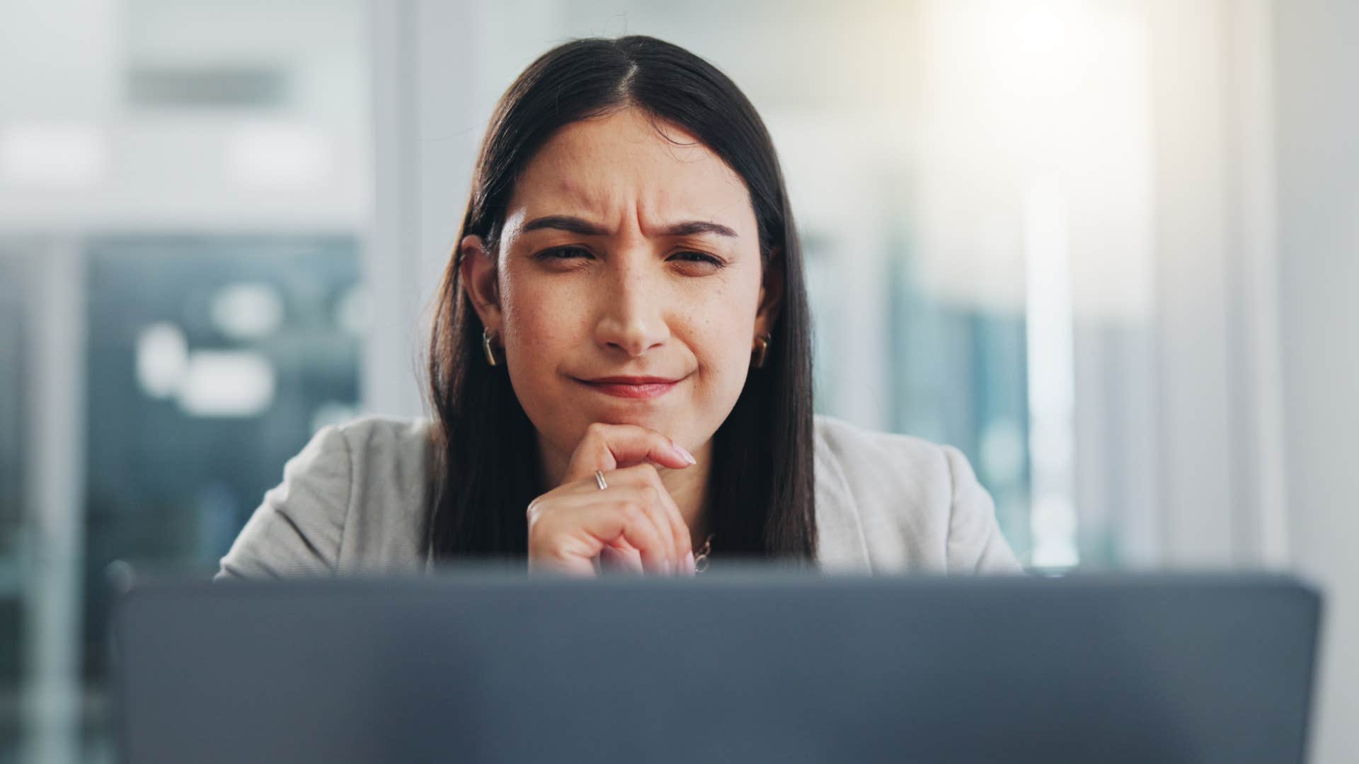 emotionally expressive woman concentrating while working on laptop