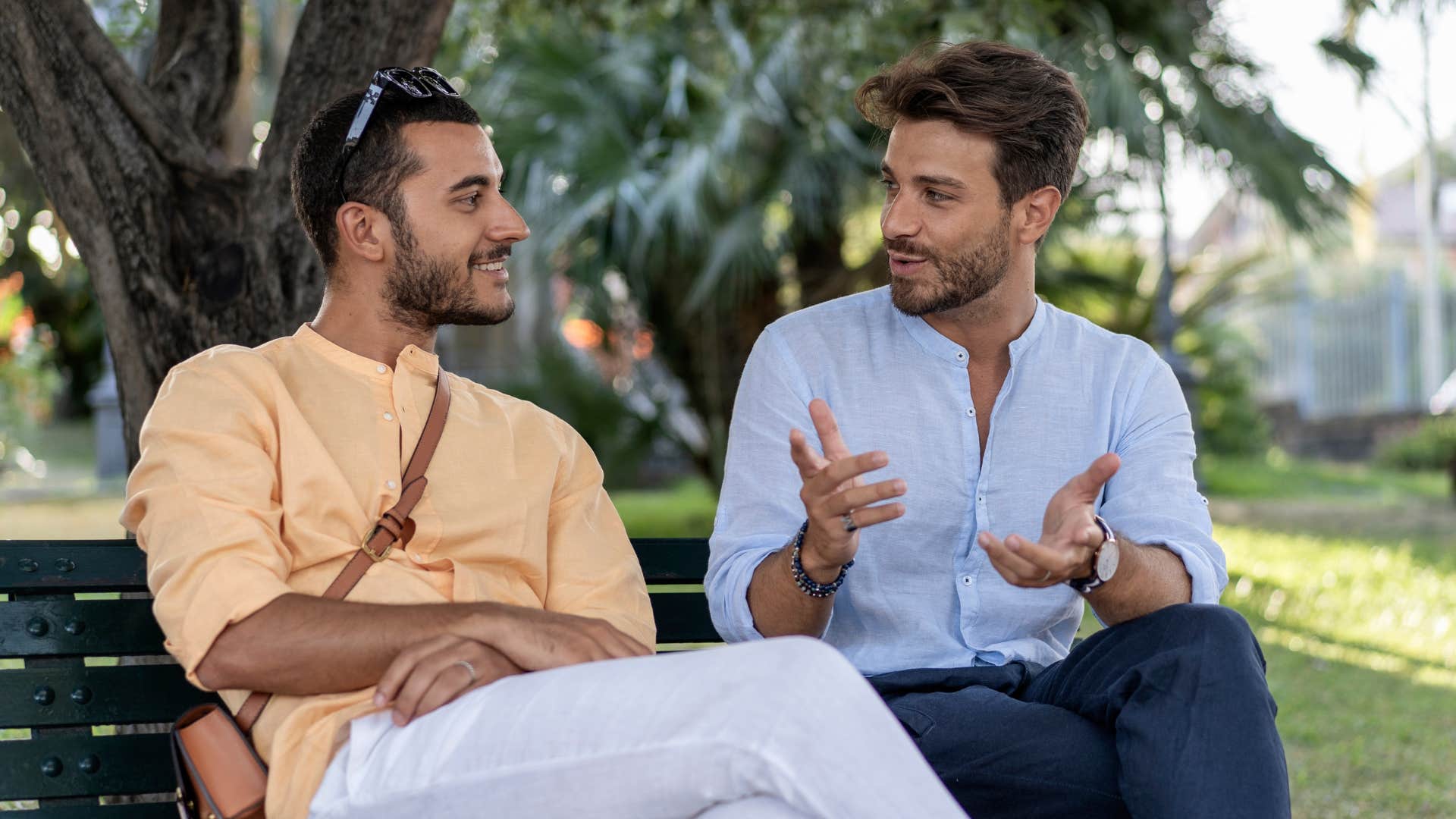 man thanking friend for his time having conversation on park bench outside