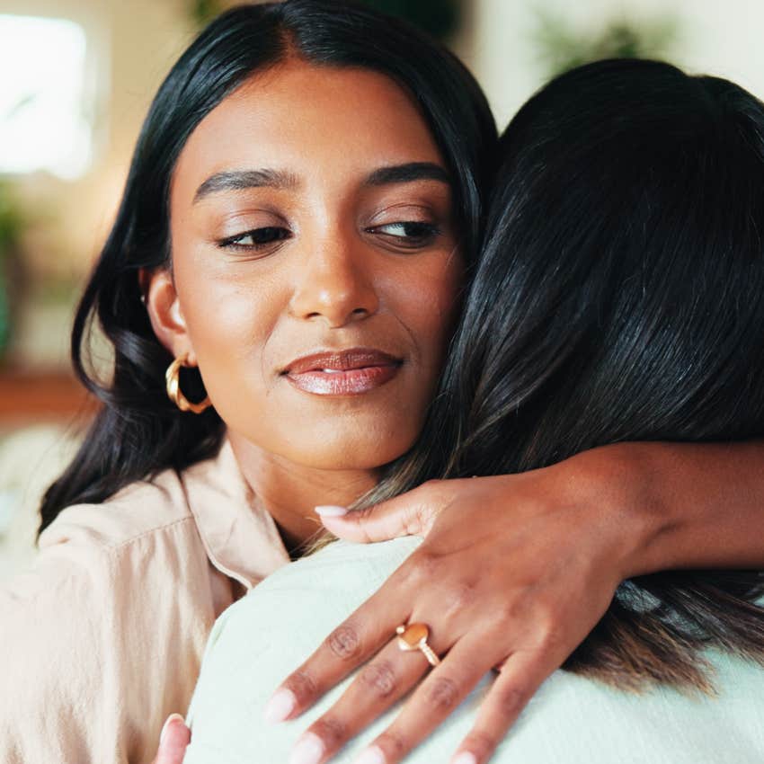 Woman hugging bad friends and looking annoyed.